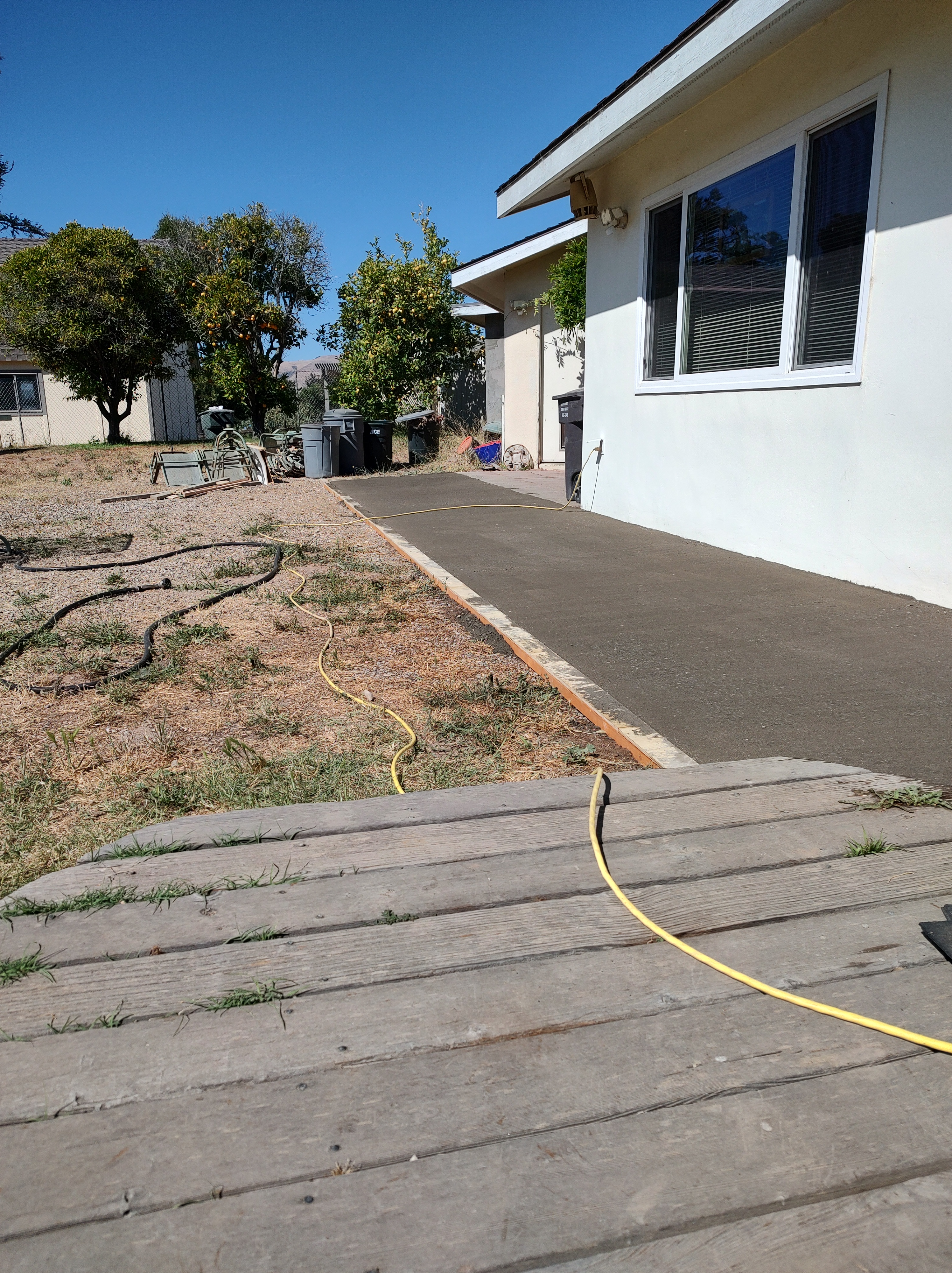 A person stands one foot in each picture, bending their knees to jump into the air simultaneously. The person has short, d...